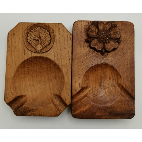 115F - Two Yorkshire oak ashtrays, of typical form, one with carved peacock signature and the other with th... 