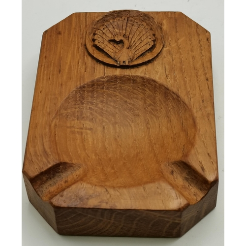 115F - Two Yorkshire oak ashtrays, of typical form, one with carved peacock signature and the other with th... 