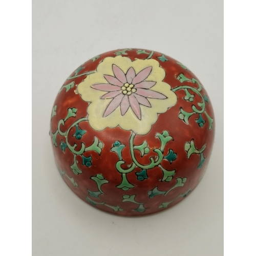 12 - A Chinese ginger jar and cover, the red ground with green foliage, blue accents, and pink and yellow... 