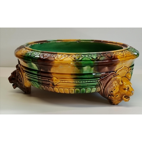 14 - A Majolica jardinière, circular, decorated in green, brown and yellow, raised on three winged zoomor... 