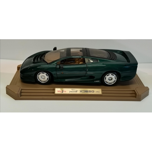 15 - A Maisto Jaguar XJ220 (1992) model car, scale 1:12, on display plinth. Plinth 47.2cm by 25.4cm