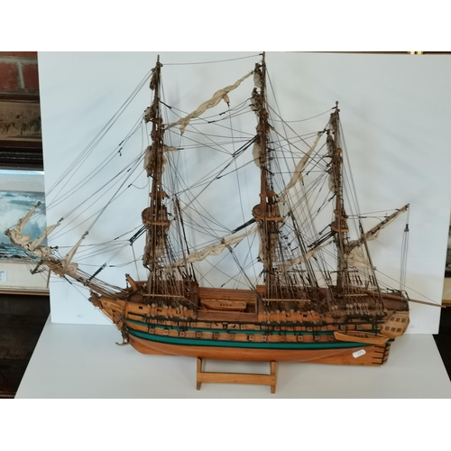 29 - A wooden model battleship, with rigging and carved figurehead, on stand. Approx. 65cm high overall (... 