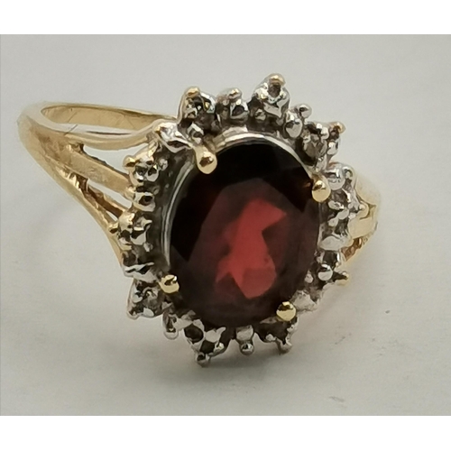 342c - Garnet & Diamond oval cluster ring set in 14ct gold comprising of a deep red oval Garnet to the cent... 