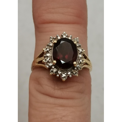 342c - Garnet & Diamond oval cluster ring set in 14ct gold comprising of a deep red oval Garnet to the cent... 