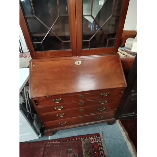 911 - A Georgian mahogany bureau bookcase with astral glazed top. the interior with Sheraton shell inlaid ... 