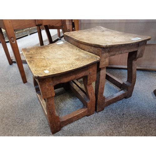 692 - Two oak dish top stools, possibly by Wilf Hutchinson, lightly adzed, each with nailed top, on four s... 