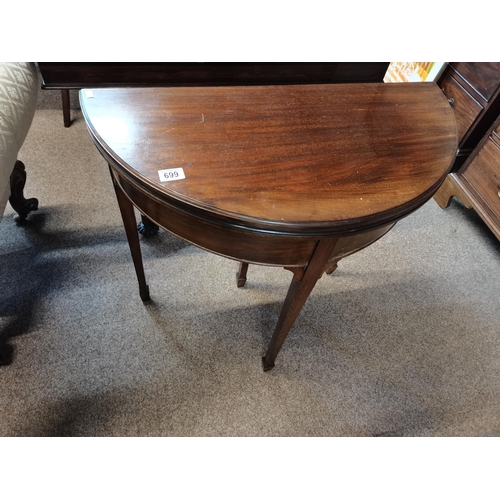 699 - A Victorian mahogany demilune foldover card table, with green baize lining, raised on four square-se... 