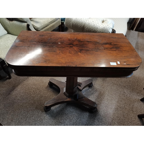 699A - A Regency style rosewood foldover card table, the top with rounded corners, raised on a tapering oct... 