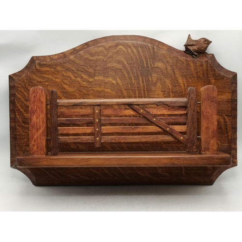 143 - Bob Hunter, a Wrenman oak wall-hanging letter rack, as a five-bar gate to a shaped back, with carved... 