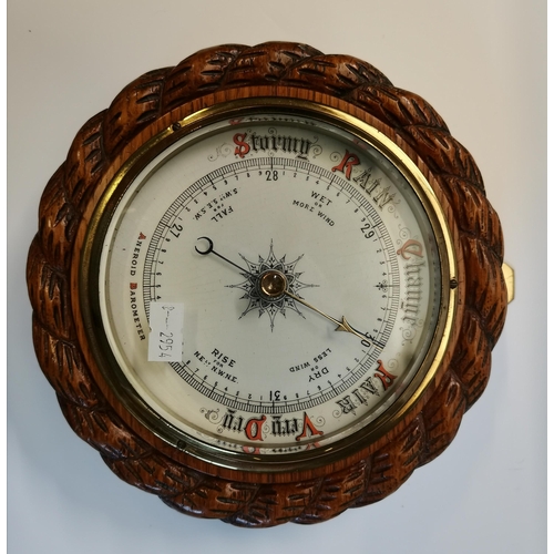 144 - An oak-mounted aneroid barometer, circular, with carved rope-twist surround, pen signature to revers... 