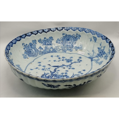 193 - A large blue and white ceramic bowl, 19th Century, oval with fluted sides, decorated in the Chinese ... 