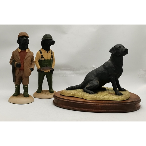 74 - A Border Fine Arts figure of a black labrador dog, seated, by Ray Ayres, 1983, on an oval wooden bas... 