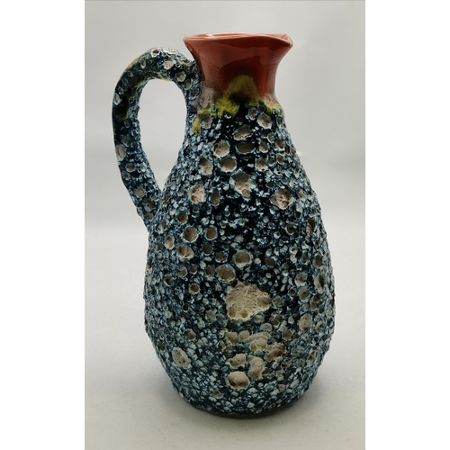 254 - A French pottery jug, the blue pitted body with lava texture, with orange glazed neck and handle, st... 