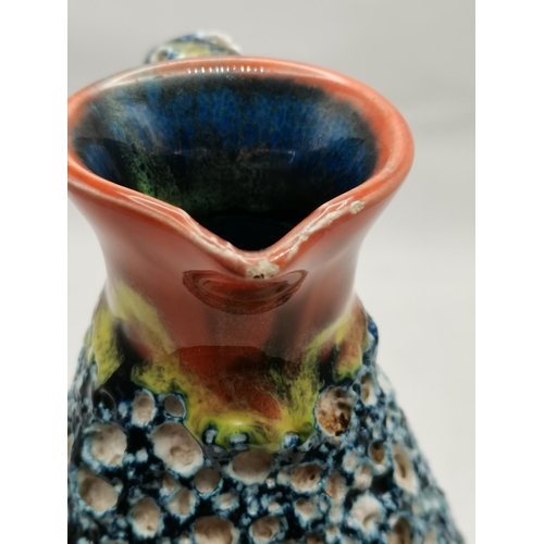 254 - A French pottery jug, the blue pitted body with lava texture, with orange glazed neck and handle, st... 