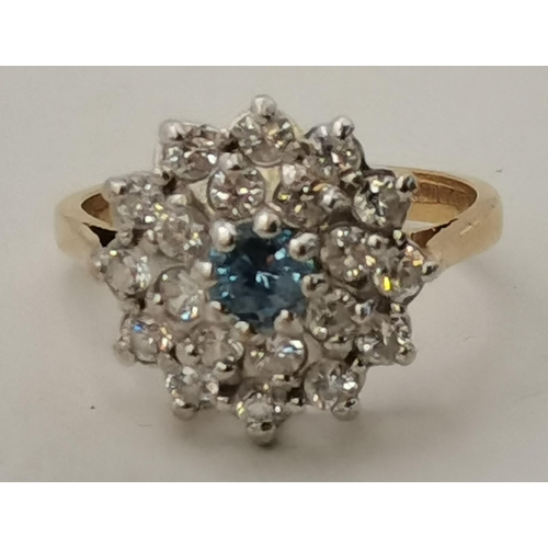 395 - A 9 carat gold cluster ring, a pale blue central stone enclosed by two circles of white stones. Ring... 