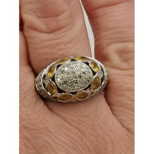 450K - A 14 carat white gold cocktail ring, pierced oval, set with citrines and white stones, stamped '14K'... 