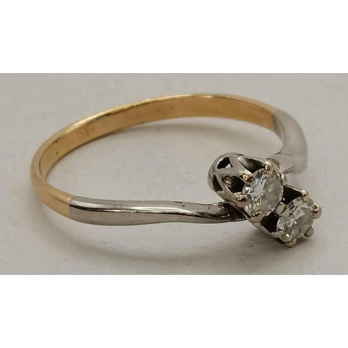 450N - An 18 carat gold and white gold diamond cross-over ring, c.1950s, stamped '18'. Ring size L, 1.8g