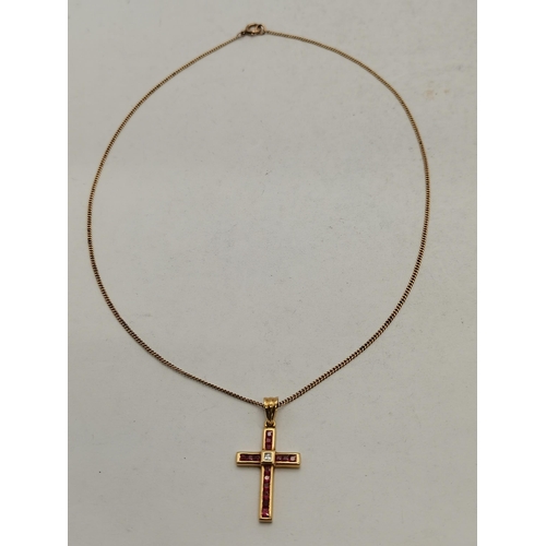 463 - An 18 carat gold and red stone crucifix, with single white stone to the centre, the cross pendant ne... 