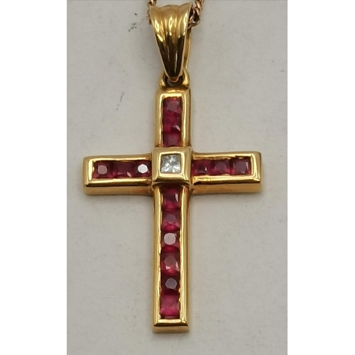 463 - An 18 carat gold and red stone crucifix, with single white stone to the centre, the cross pendant ne... 