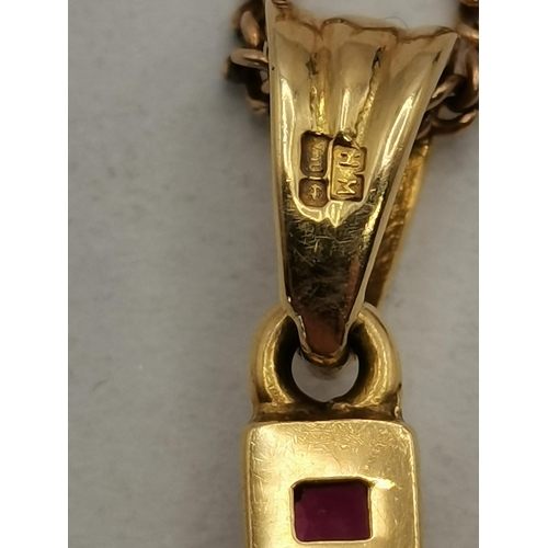 463 - An 18 carat gold and red stone crucifix, with single white stone to the centre, the cross pendant ne... 