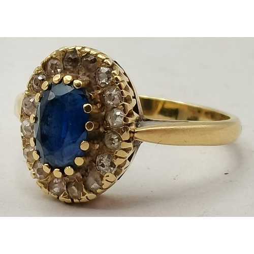 475A - An 18 carat gold sapphire and diamond cluster ring, the oval central blue stone enclosed by small wh... 