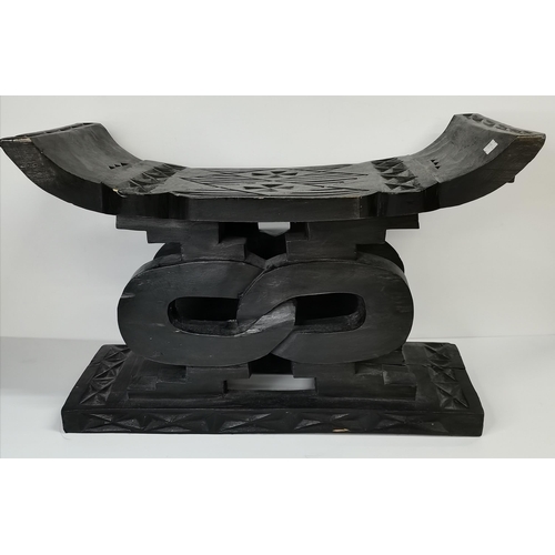 527 - An African carved and ebonised stool, rectangular, with chip-carved decoration; together with a pain... 