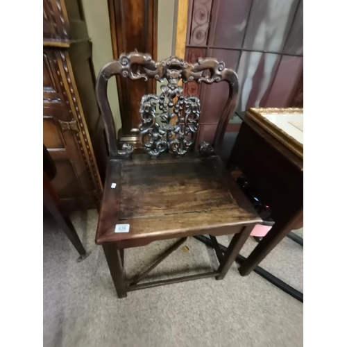 636 - A Chinese heavily carved hall chair with flower and devil style decoration