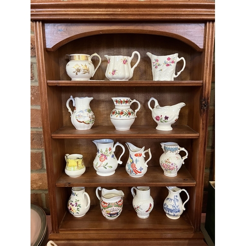 750 - A collection of ceramic cream jugs in a wooden shelf display unit, including examples by Royal Worce... 