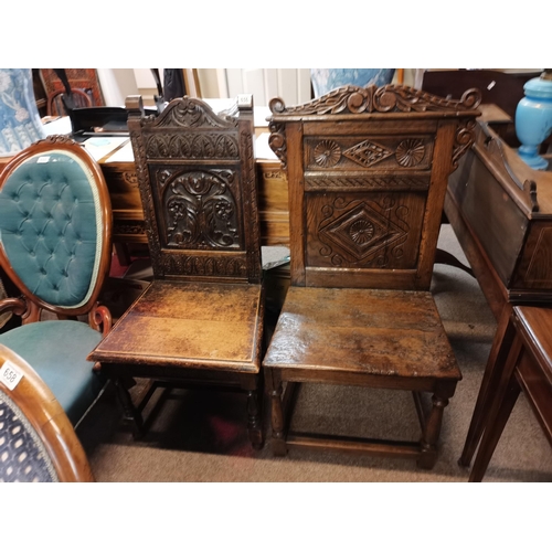 656 - 2 x early oak hall/ church chairs with carved decoration