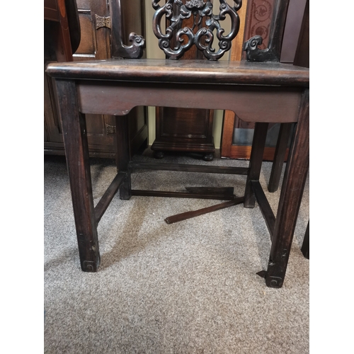 636 - A Chinese heavily carved hall chair with flower and devil style decoration