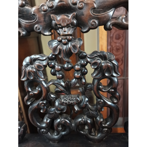 636 - A Chinese heavily carved hall chair with flower and devil style decoration