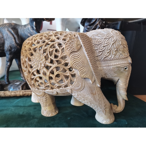 516 - A soapstone carved Asian elephant model, three in one, the ornately pierced back of the largest reve... 