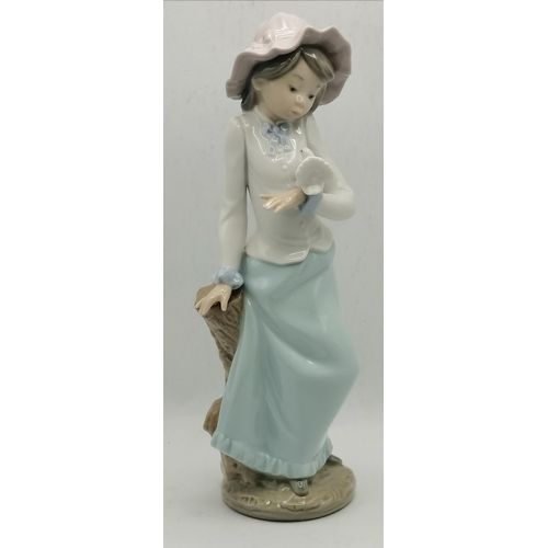 183 - Two Nao porcelain female figures of a hatted girl with a fantail dove on her hand, and a girl in a n... 