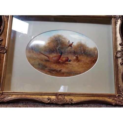 230D - A painted porcelain plaque by Milwyn Holloway, oval, depicting pheasants in an autumnal landscape, s... 