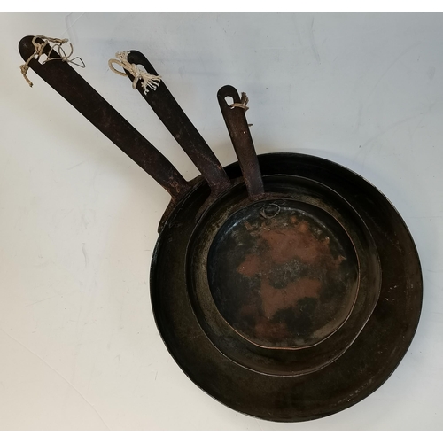 24 - A graduated set of three copper skillets, early 20th Century, the larger two pans stamped 'W.M. STIL... 