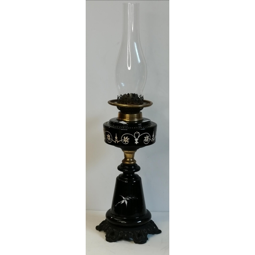 25 - Two Victorian glass and brass oil lamps, one with black glass body and reservoir with white enamel p... 