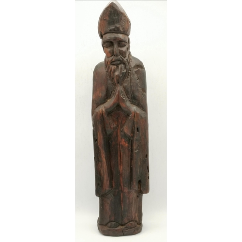 83 - A wooden wall bracket as a shield carved with a crest; together with a carved figure of a bishop. (2... 