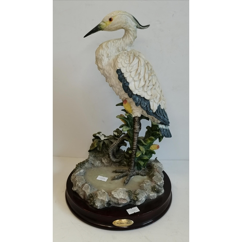 87 - A large resin model of a heron/stork, the wading bird standing on one leg to a naturalistic ground, ... 