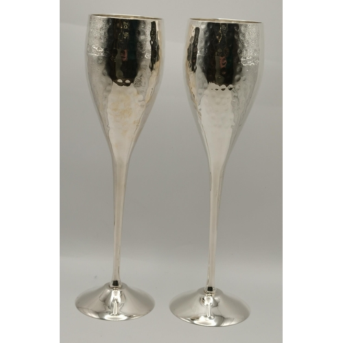 305 - A pair of silver-plated champagne flutes, together with a small silver-plated heart-shaped dish, all... 