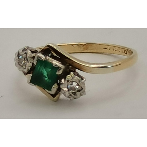 394 - A 9 carat gold and platinum emerald and diamond three-stone crossover ring, the square-cut emerald e... 