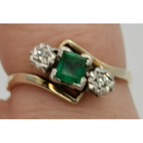 394 - A 9 carat gold and platinum emerald and diamond three-stone crossover ring, the square-cut emerald e... 