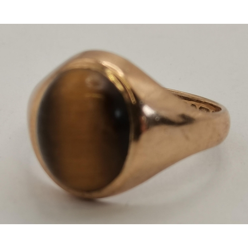 397 - A 9 carat gold tiger's eye ring, the oval cabochon stone to an open-backed setting, the shank hallma... 