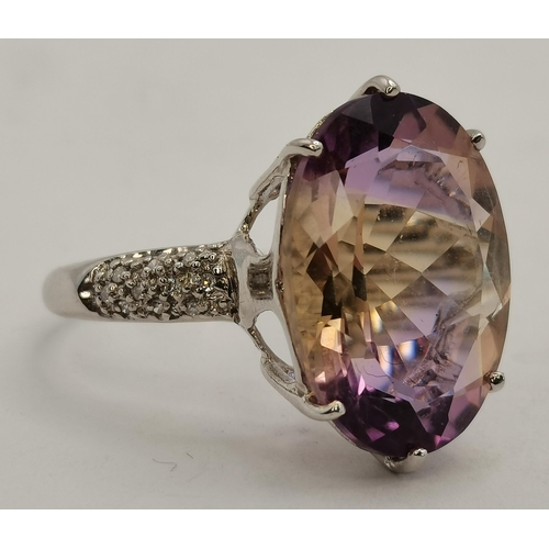 397A - A 9 carat white gold and lilac stone dress ring, the large oval stone in a raised and pierced claw s... 