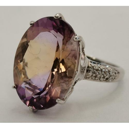 397A - A 9 carat white gold and lilac stone dress ring, the large oval stone in a raised and pierced claw s... 