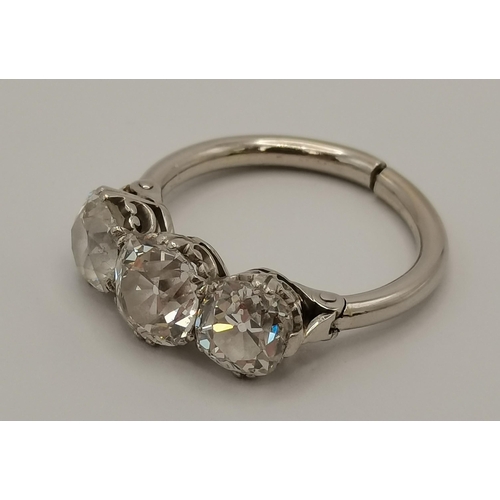 400 - An impressive platinum three-stone diamond ring, the old brilliant cut stones in C-scroll claw setti... 