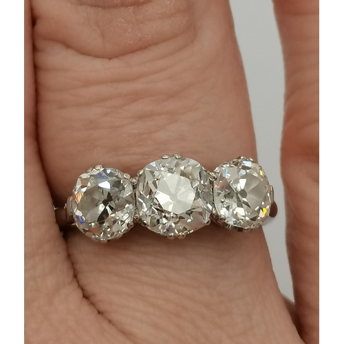 400 - An impressive platinum three-stone diamond ring, the old brilliant cut stones in C-scroll claw setti... 