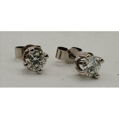 406f - A pair of 18ct gold white gold claw-set single stone diamond earrings, diamonds 0.70cts each