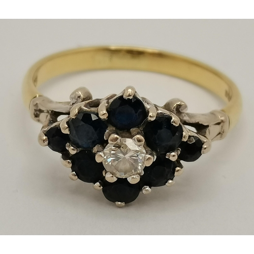 410 - An 18 carat gold blue and white stone cluster ring, the solitaire white stone enclosed by eight blue... 