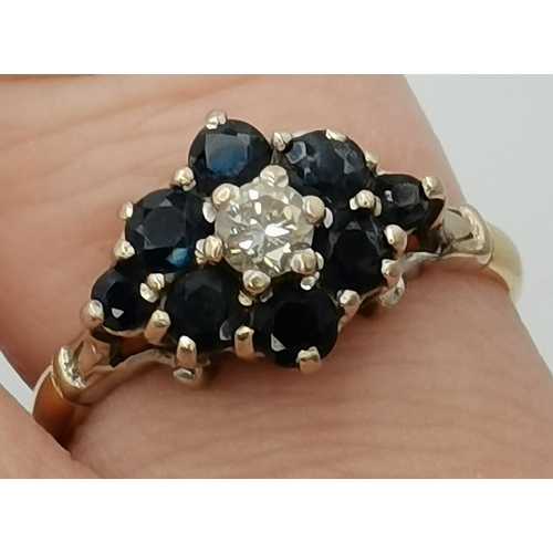 410 - An 18 carat gold blue and white stone cluster ring, the solitaire white stone enclosed by eight blue... 