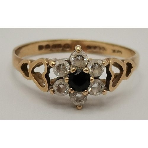 434 - A 9 carat gold cluster ring, the central blue stone surrounded by six white stones in a flowerhead f... 